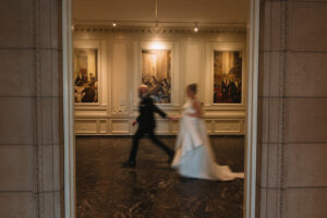 Photo of couple walking in a museum at their wedding.