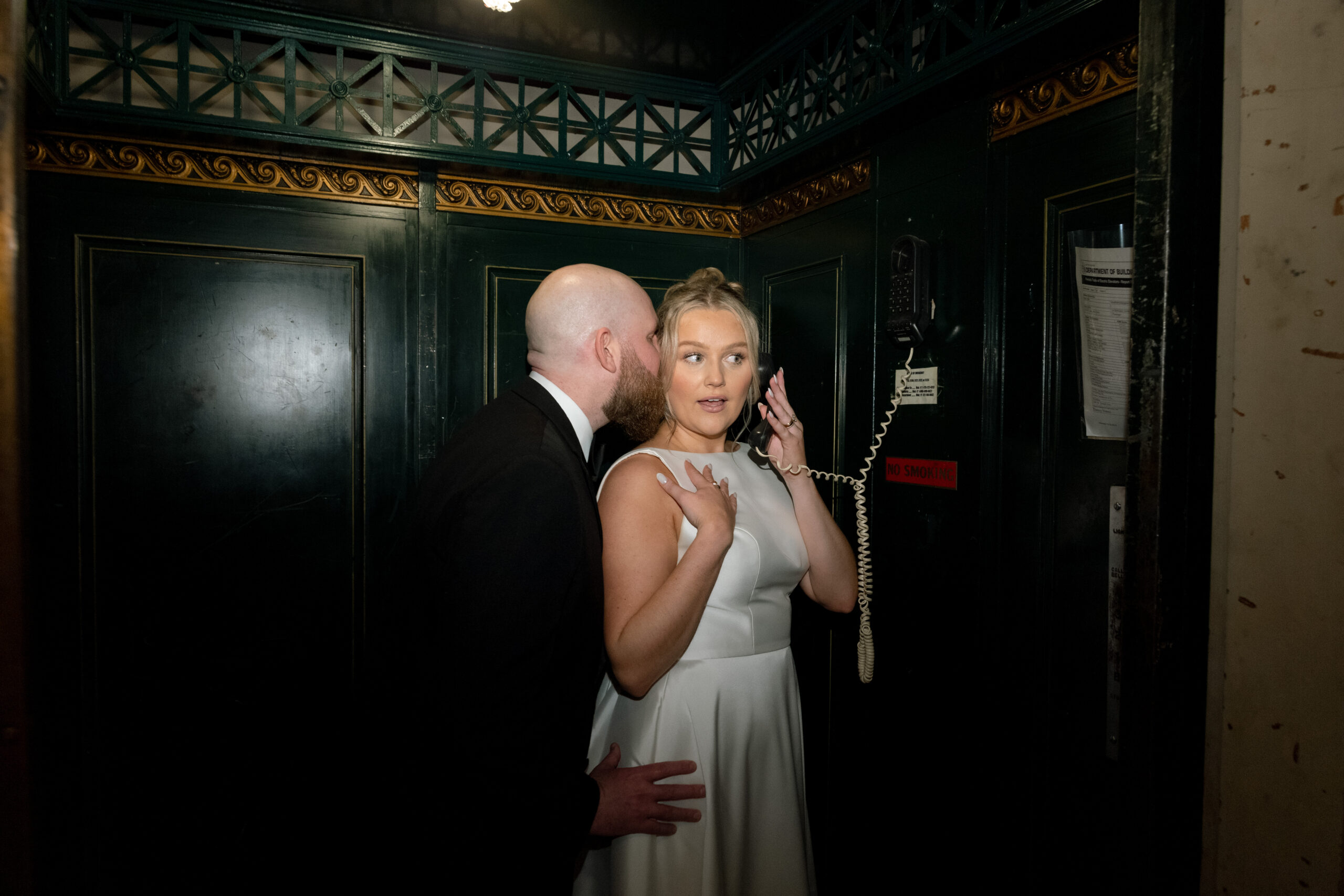 Photo of a couple making a phone call at their wedding.