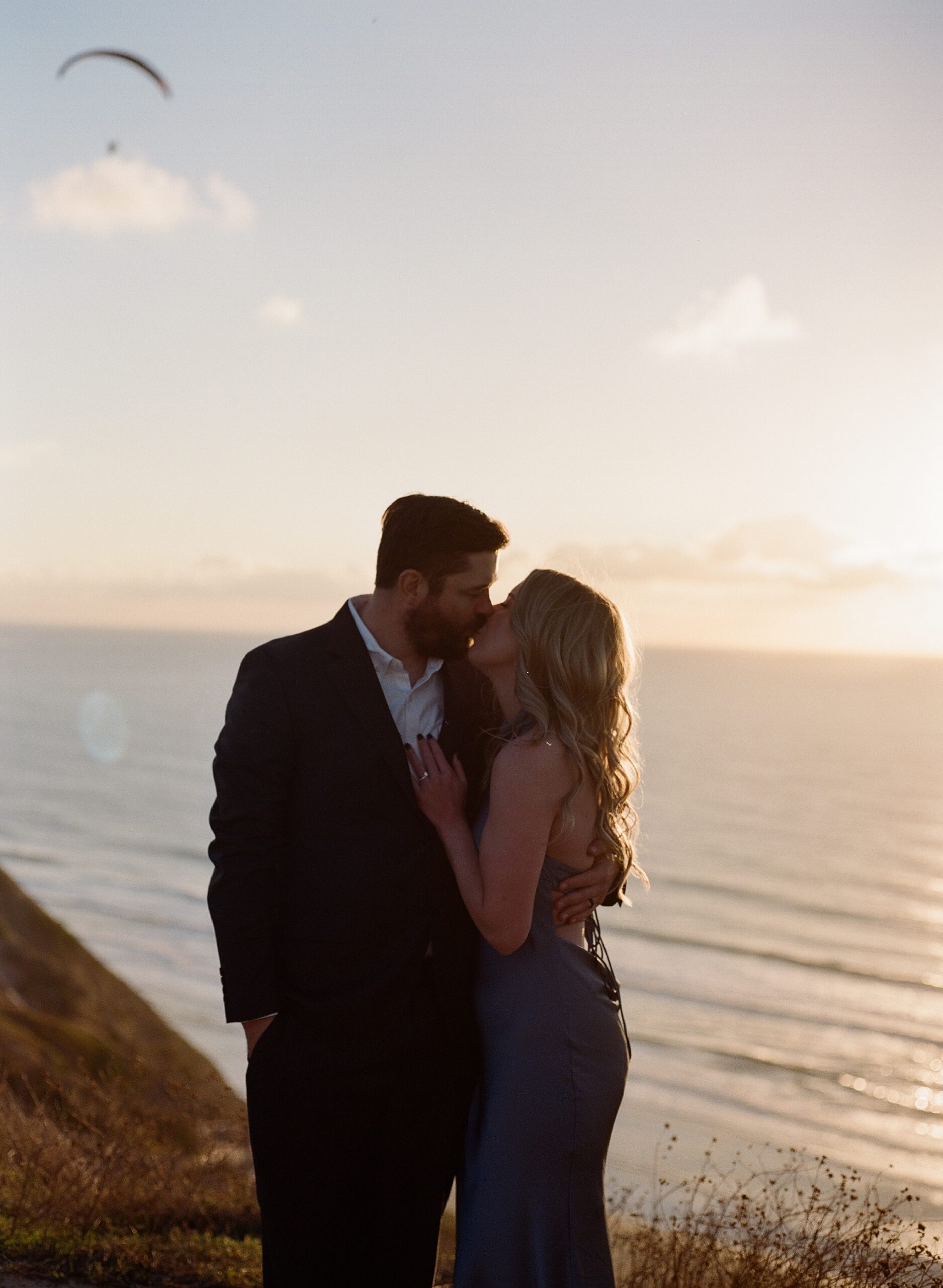 couple kissing at torrey pines during golden hour