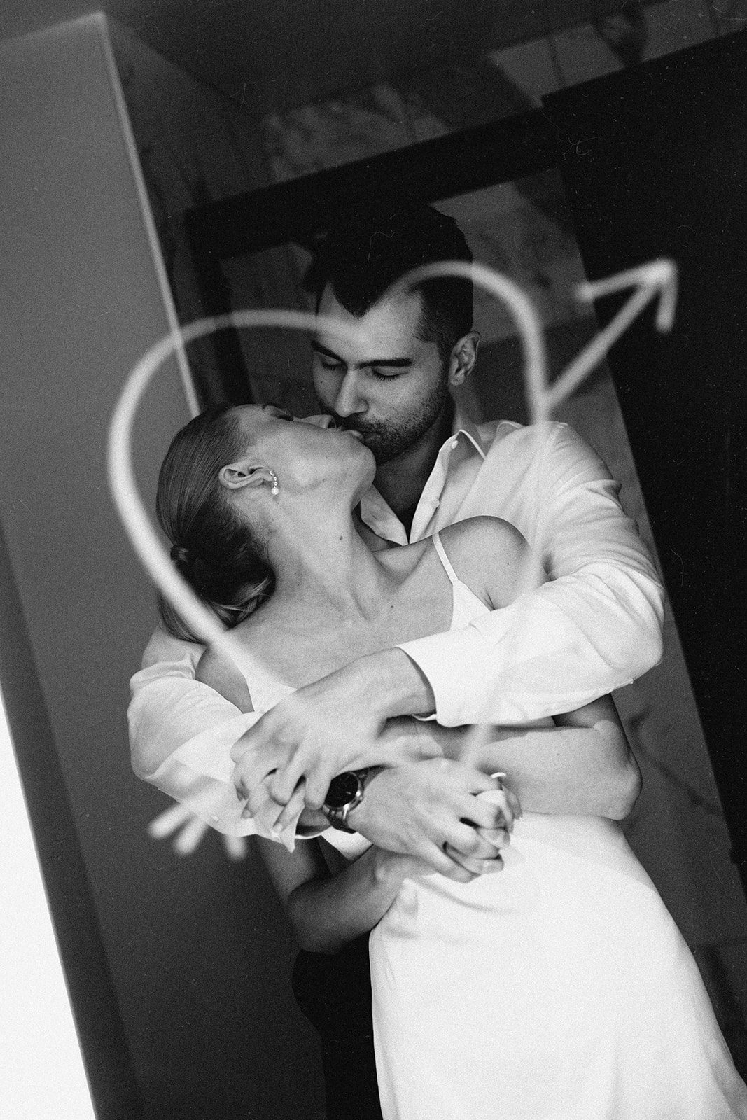 couple kissing in front of hotel mirror