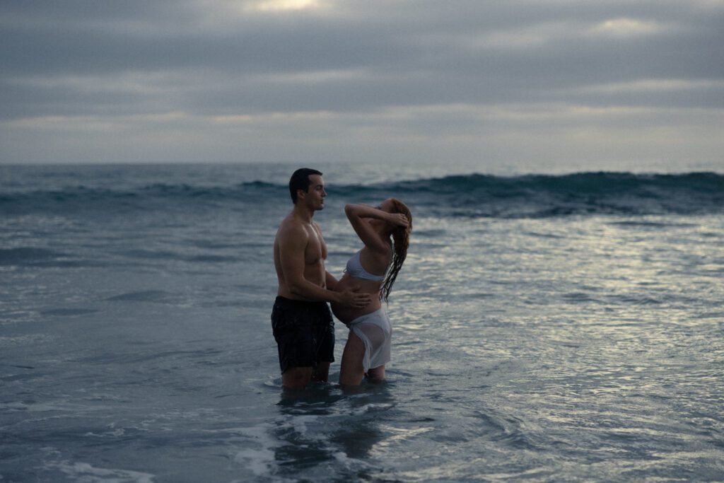couple playing in the ocean at torrey pines beach