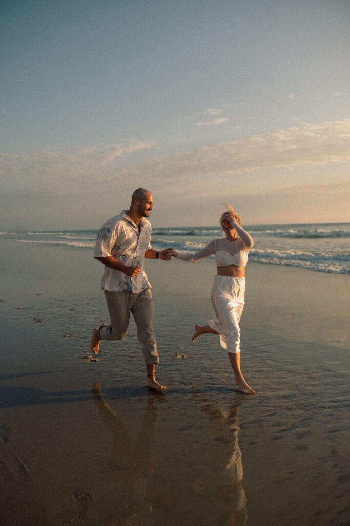 running along the coastline during engagement pictures