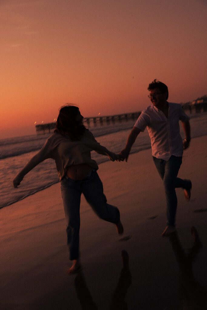 wrapped up in love. couple shares a romantic embrace during their pacific beach pregnancy announcement. cinematic pregnancy photos