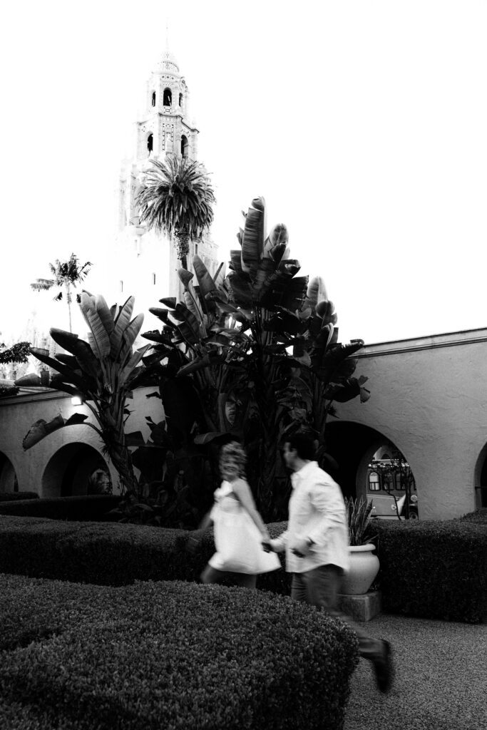 engagement photos of couple running around balboa park