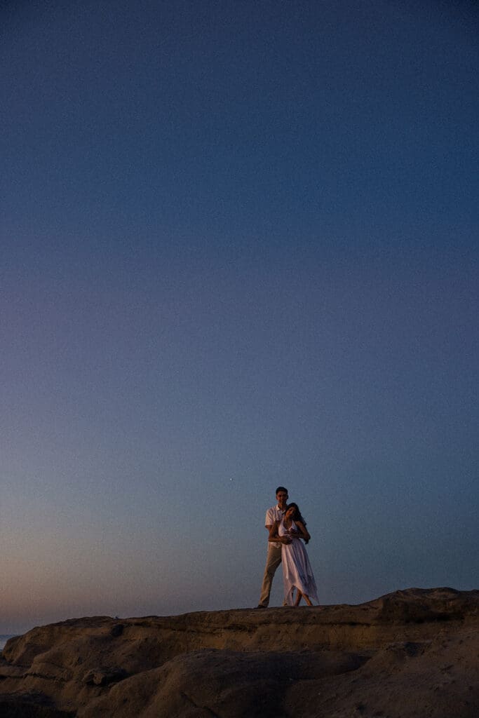 cinematic couples photos on the coast in front of the big blue sky