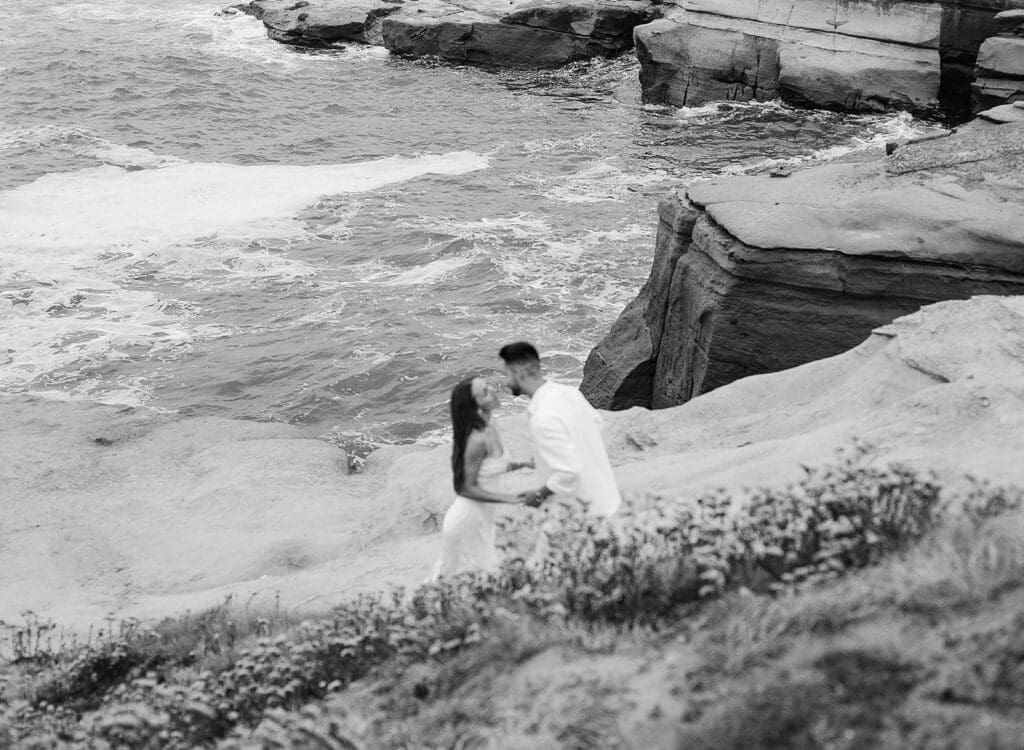 black and white film engagement photos of couple at sunset cliffs in san diego, ca
