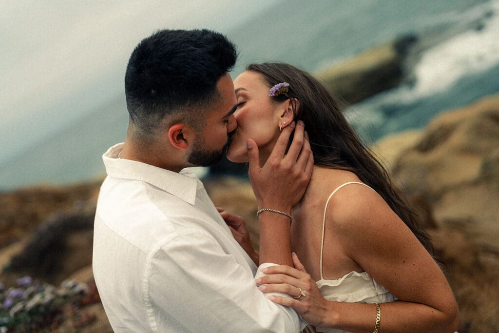 couple kissing during their coastal engagement photos