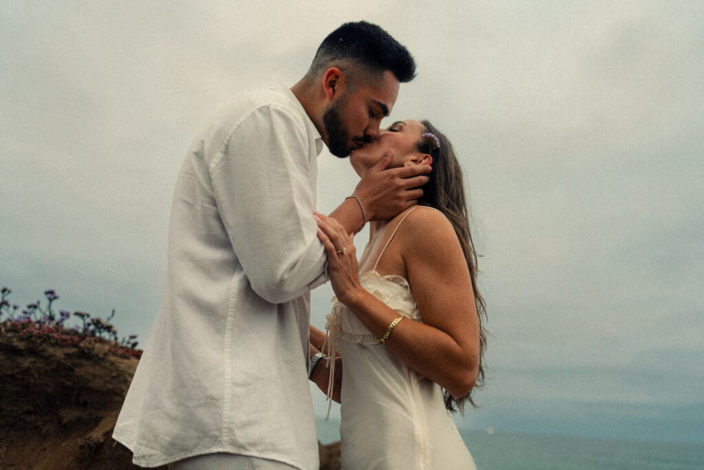 couple kissing during their coastal engagement photos