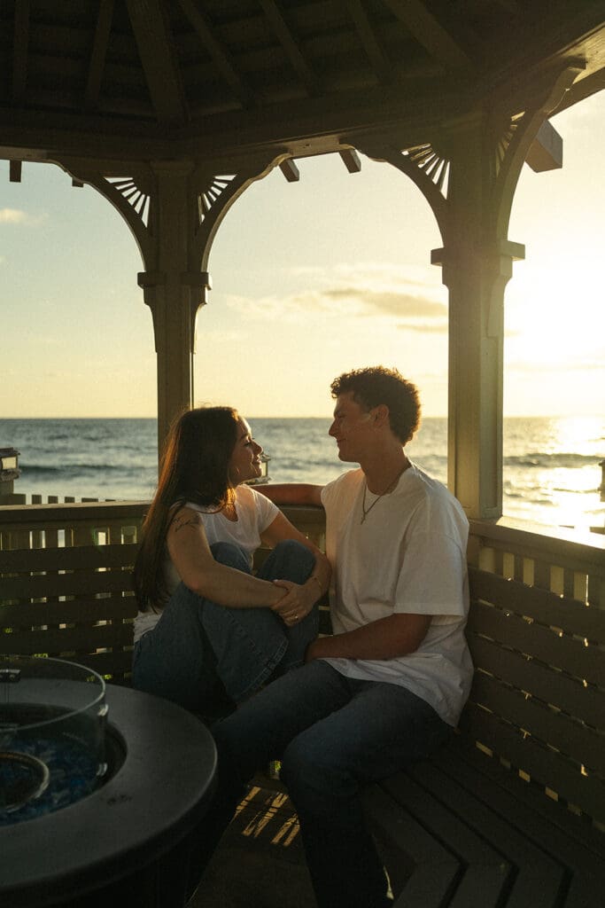 couple cuddles up under a palm tree under the beautiful blue san diego skies